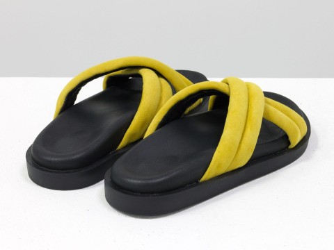 Літні шльопанці яскраво-жовтого кольору з ніжної замші на чорній підошві без підборів.