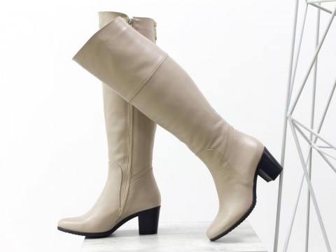 Високі жіночі чоботи з натуральної шкіри світло-бежевого кольору на підборах.